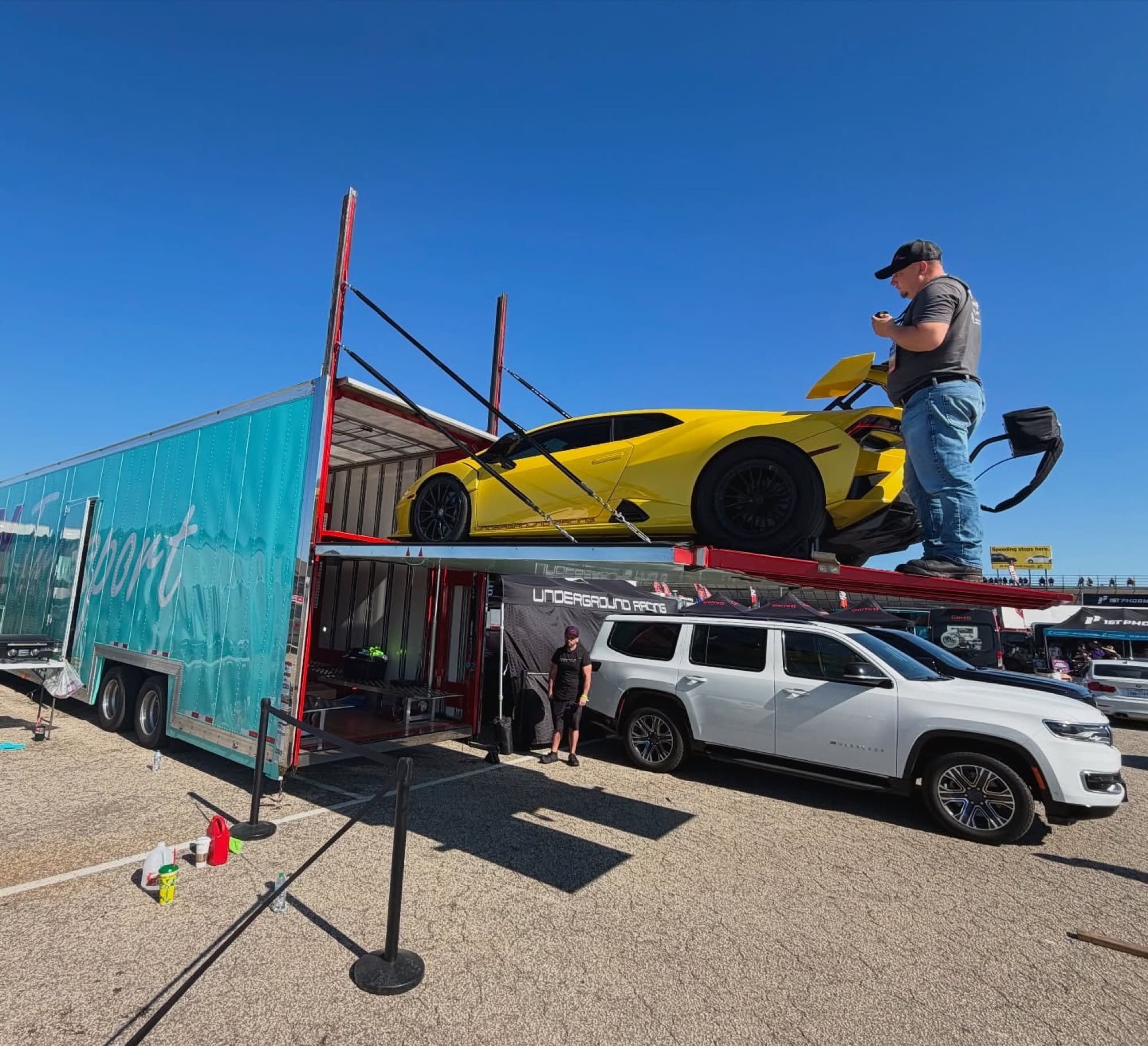 Yellow Lamborghini Huracán STO on the VIY trailer liftgate at a track event